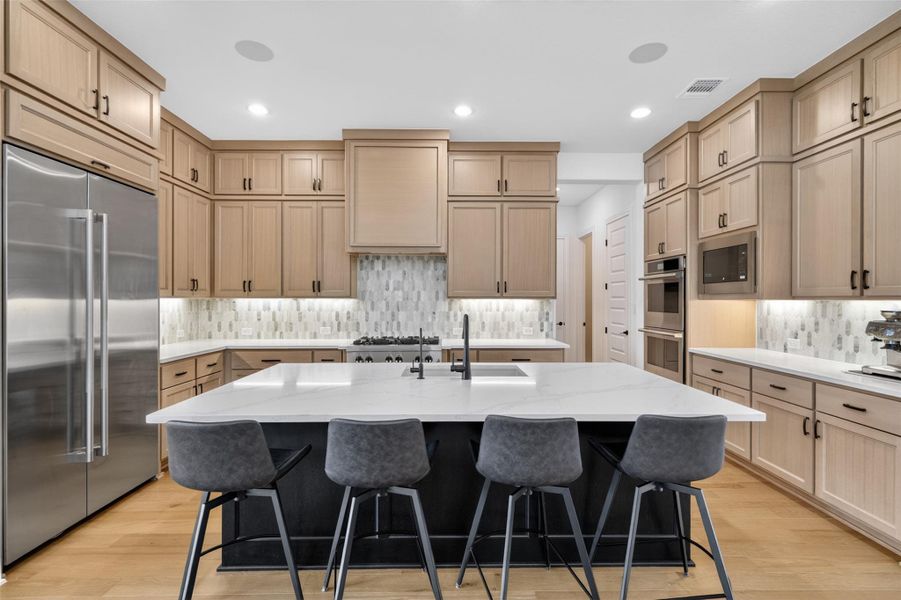 Culinary delights await in this modern kitchen with extensive cabinetry and a grand island. Culinary delights await in this modern kitchen with extensive cabinetry and a grand island.
