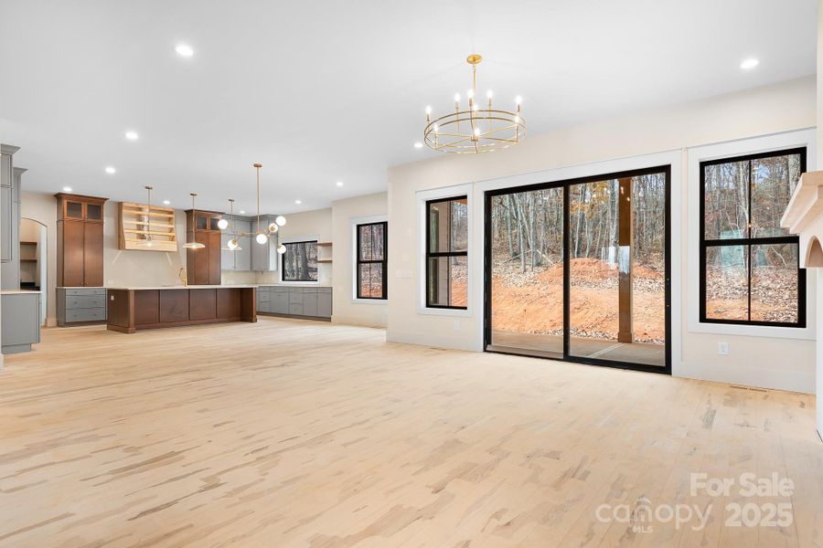 A refined open-concept floor plan with room to gather-anchored by designer lighting- and surrounded by windows that bring the outdoors in.
