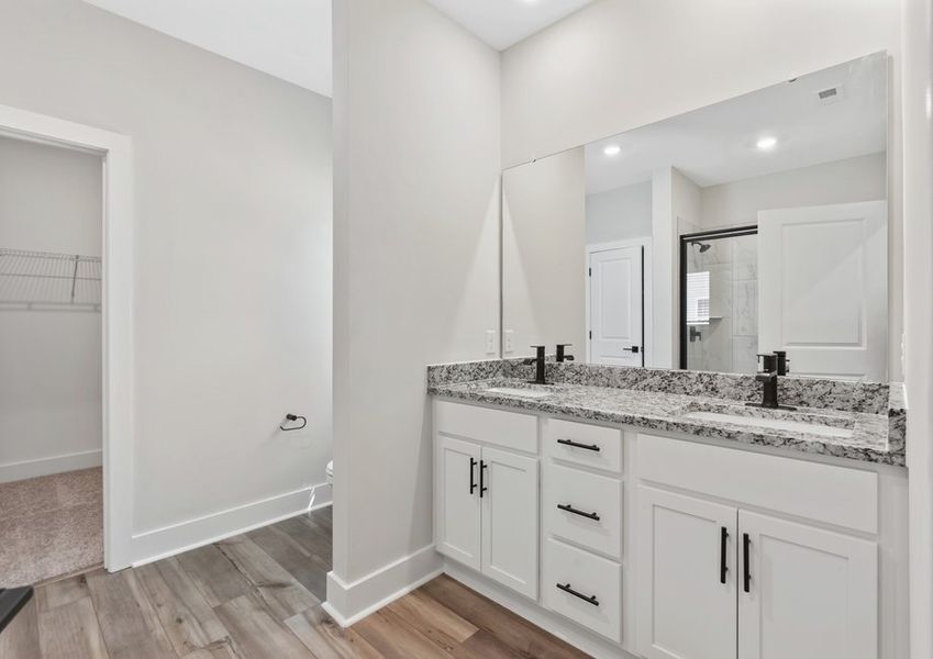 The master bathroom has dual sinks and a glass-enclosed shower