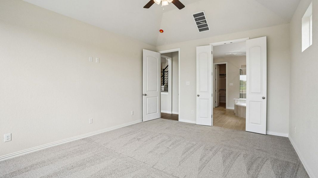 Owner's Suite features plenty of windows allowing natural light to flow, a raised ceiling, and ceiling fan
