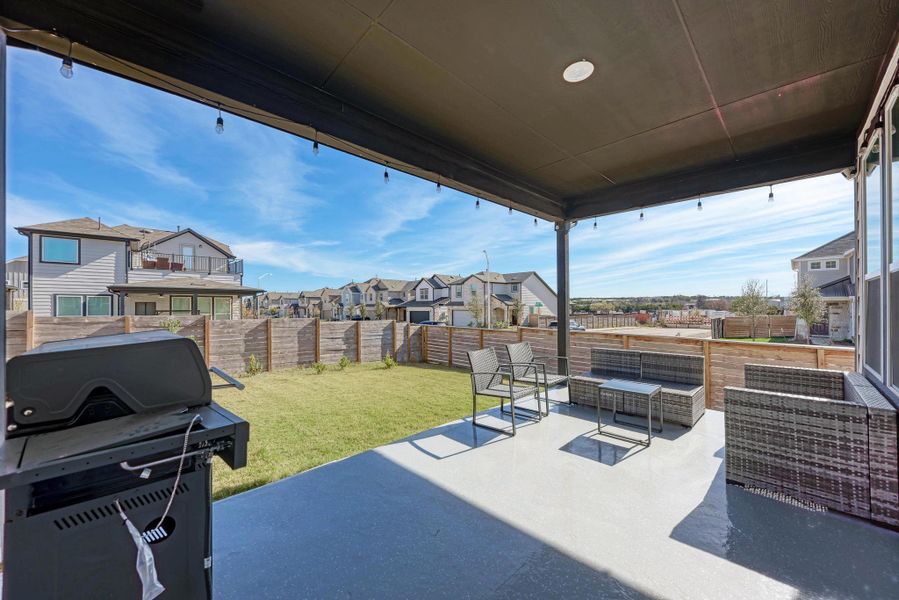 Fenced backyard with an outdoor living space, a residential view, a patio area, and a grill