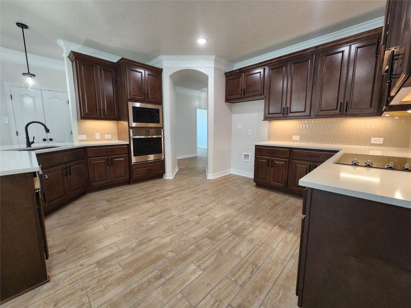 A contemporary kitchen features rich cabinetry, built-in appliances, and sleek countertops, ready for culinary creations. A contemporary kitchen features rich cabinetry, built-in appliances, and sleek countertops, ready for culinary creations.