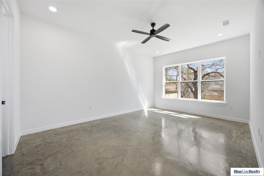 Empty room featuring concrete flooring, ceiling fan, and recessed lighting