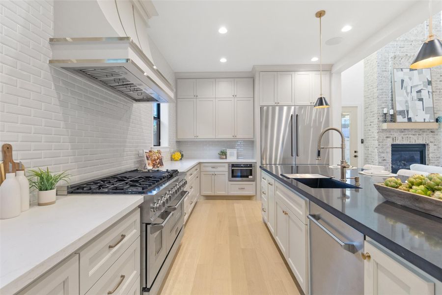 From this angle, the island becomes the heart of the home. You’ve got seating for casual meals, a deep sink for easy cleanup, and a clear sightline into the living area so nothing feels disconnected. The stainless appliances, custom cabinetry, and warm wood floors balance clean design with livability—this is a kitchen you actually use, not just admire.