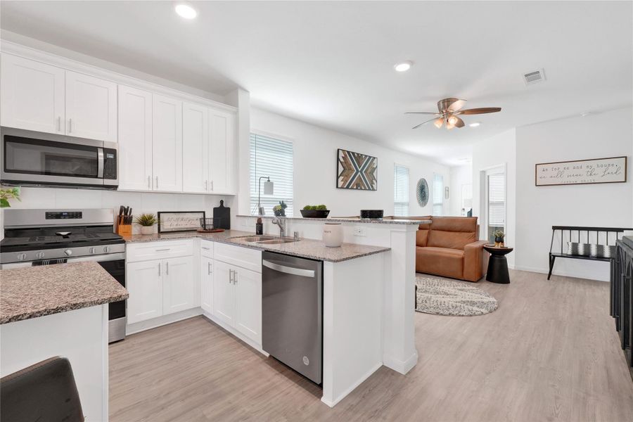 Fall in love with a modern chef’s kitchen featuring stainless-steel appliances, sleek cabinetry, ample counter space, and a large breakfast bar, creating a perfect balance of beauty and functionality.