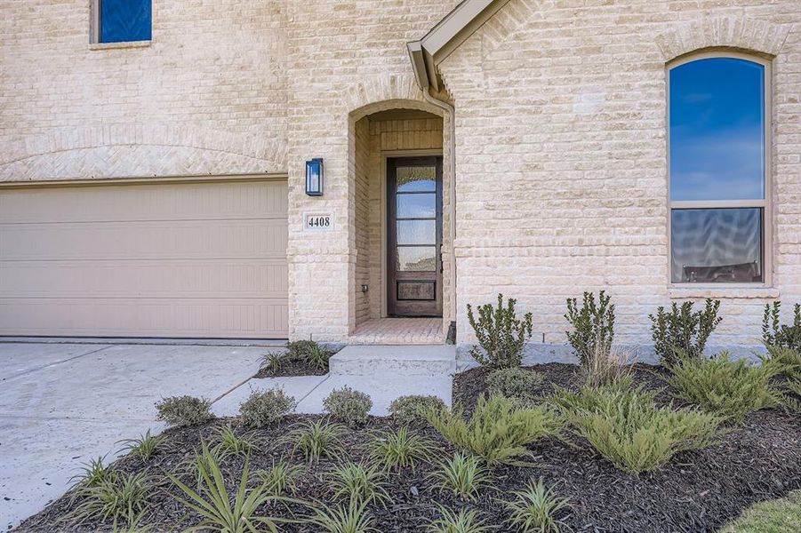 Property entrance featuring brick siding and driveway