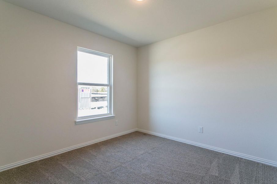 Unfurnished room featuring dark carpet and baseboards