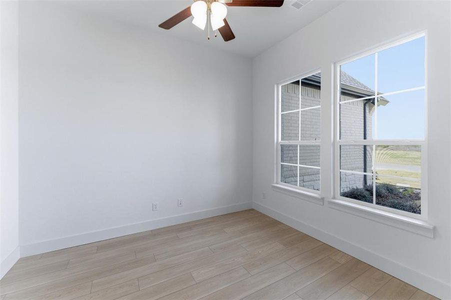 Unfurnished room featuring light wood-type flooring and ceiling fan
