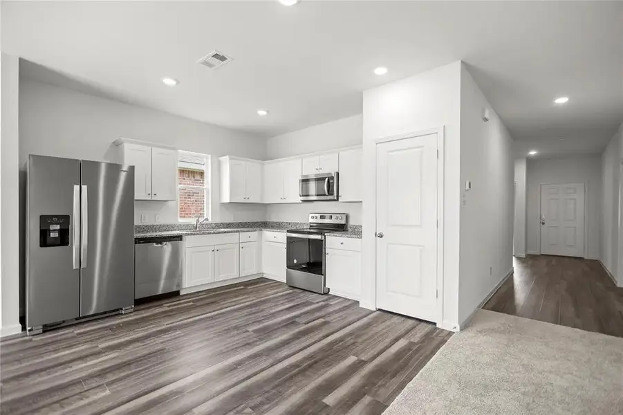 Kitchen layout with extended counter run, open pass-through to living area, and adjacent pantry access.