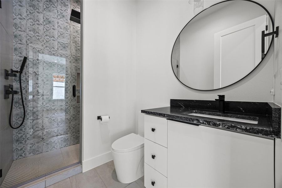 Full bathroom featuring vanity, a shower stall, and light tile patterned floors Full bathroom featuring vanity, a shower stall, and light tile patterned floors