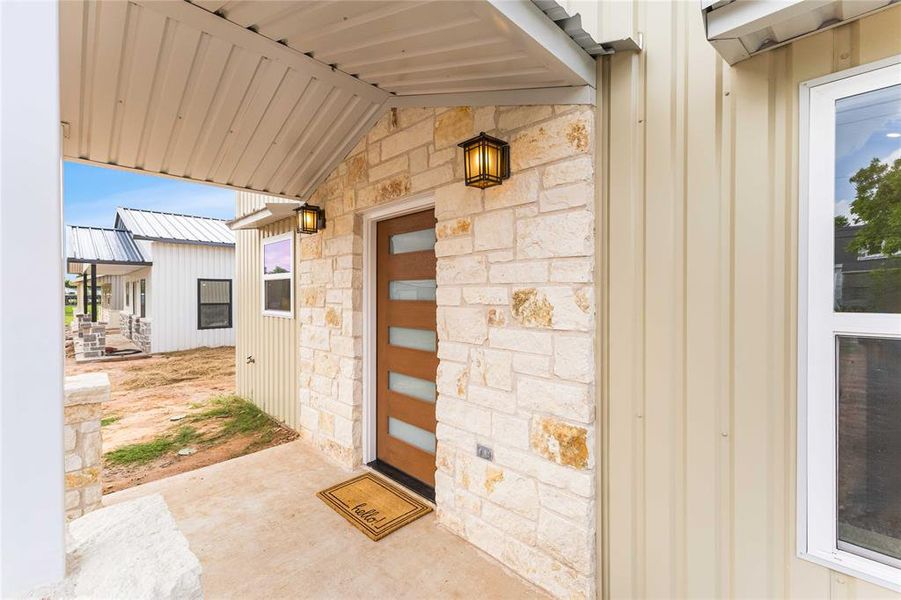 Doorway to property with stone siding and board and batten siding Doorway to property with stone siding and board and batten siding