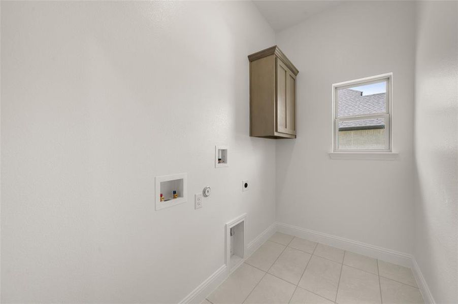 Laundry room featuring hookup for an electric dryer, cabinet space, hookup for a washing machine, hookup for a gas dryer, and light tile patterned flooring