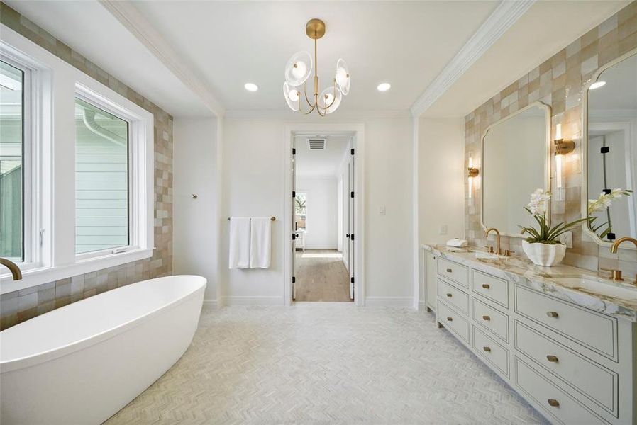 Elegant free-standing bathtub complemented by beautiful Newport brass fixtures, basked in natural light from a large window with a serene view.