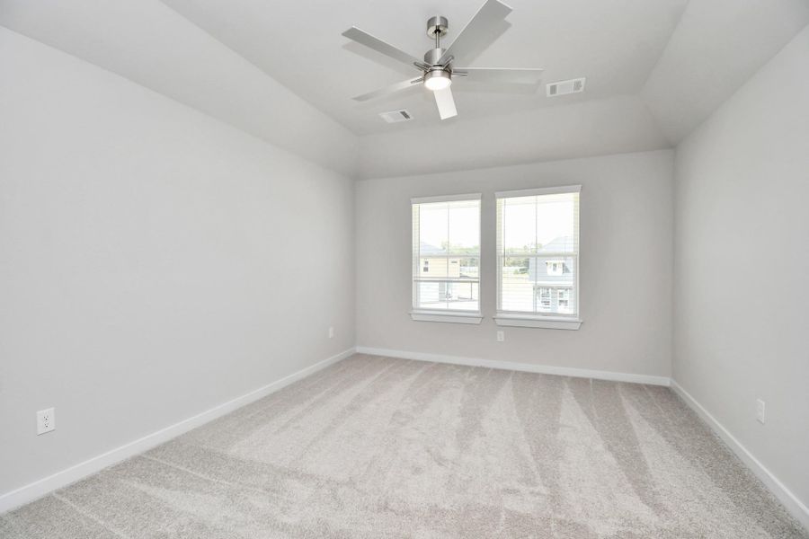 Secondary bedroom features plush carpeting, large windows that let in plenty of natural light, bright paint, and spacious closets. Sample photo of completed home with similar floor plan. Actual colors and selections may vary.