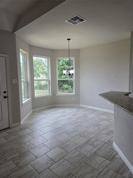 Unfurnished dining area with tile flooring and an inviting chandelier