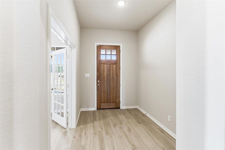 Entrance foyer with light wood-style flooring and baseboards