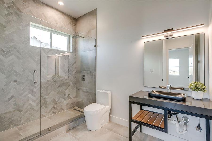 Bathroom featuring plenty of natural light, a stall shower, and tile patterned flooring Bathroom featuring plenty of natural light, a stall shower, and tile patterned flooring