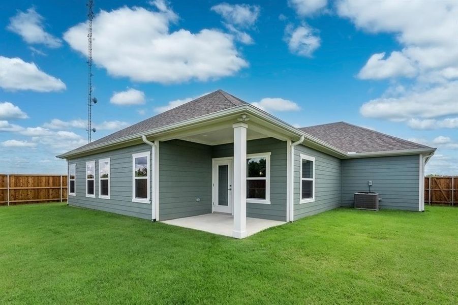 Rear view of house with central AC, a patio, and a yard