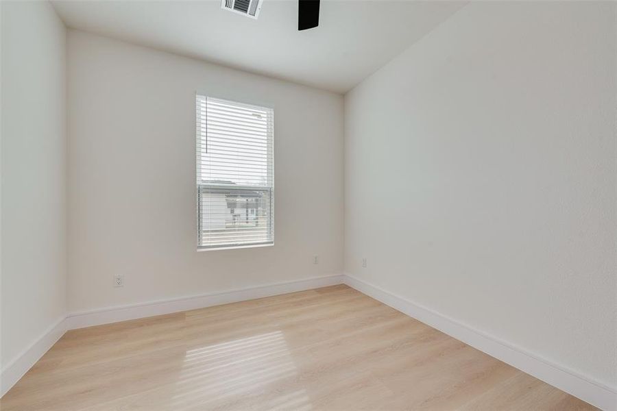 Unfurnished room with ceiling fan and light wood-type flooring