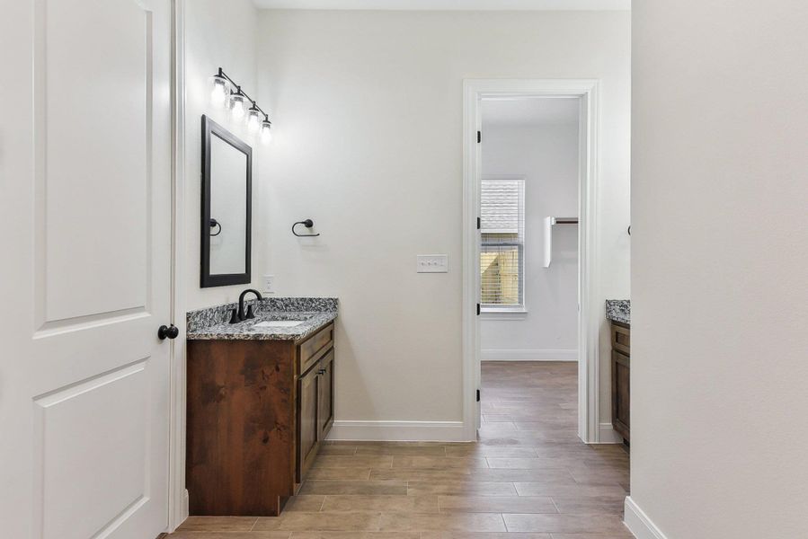 Bathroom with vanity, baseboards, and wood finished floors Bathroom with vanity, baseboards, and wood finished floors