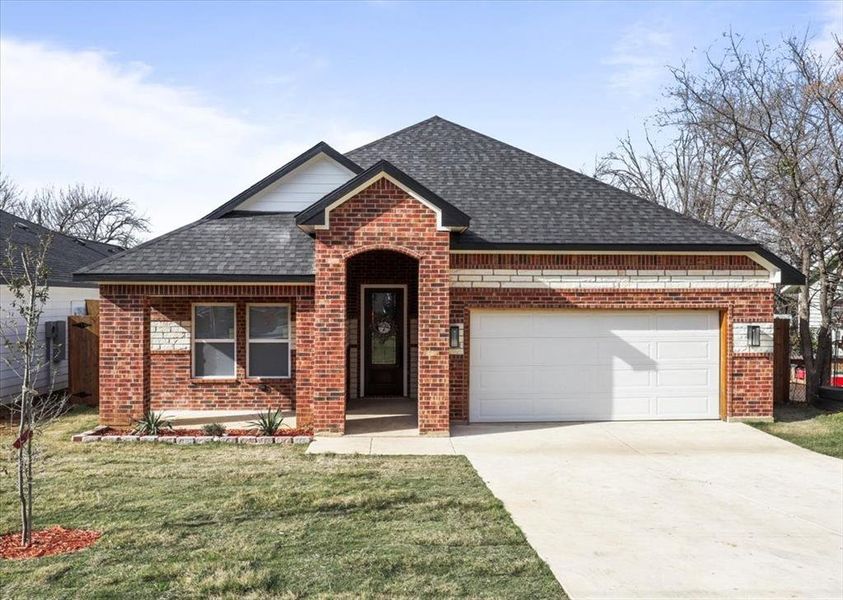 View of front of house with a front lawn and a garage