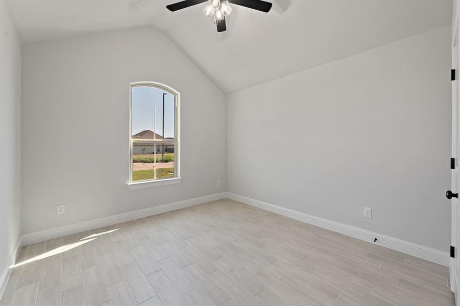 Unfurnished room with lofted ceiling and wood finish floors Unfurnished room with lofted ceiling and wood finish floors