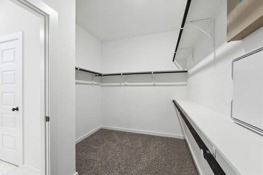 This spacious walk-in closet offers plenty of storage, making it easy to keep your wardrobe organized and accessible. With ample hanging space and shelving, it's designed to meet all your storage needs, ensuring your belongings are neatly arranged.