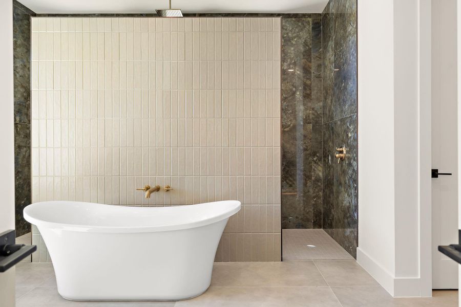 Full bathroom featuring tile patterned floors, a freestanding bath, tile walls, and walk in shower