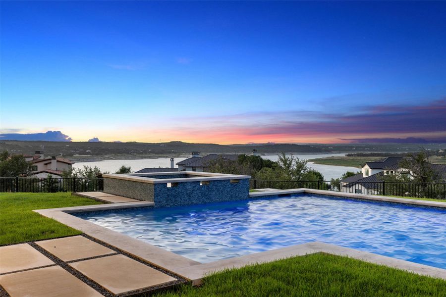 View of swimming pool featuring a fenced backyard, a patio area, a pool with connected hot tub, and a water view