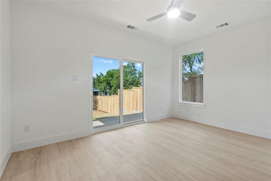 Empty room with wood finished floors and a ceiling fan Empty room with wood finished floors and a ceiling fan