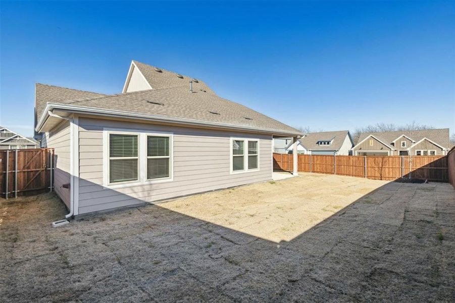 Expansive backyard featuring wood privacy fencing, a concrete patio, and light-colored siding