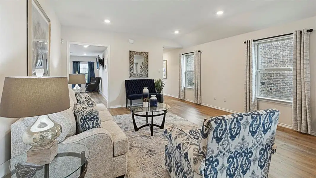 Living room featuring light wood-style floors, recessed lighting, and vaulted ceiling Living room featuring light wood-style floors, recessed lighting, and vaulted ceiling