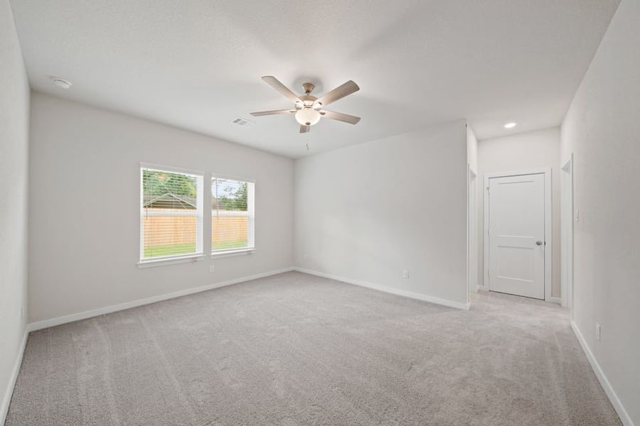 A room with a ceiling fan and a window.