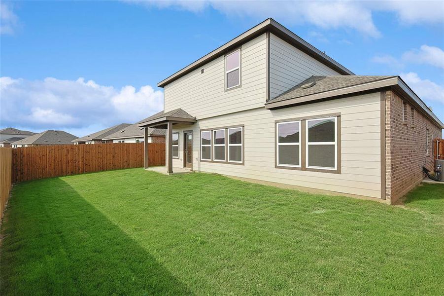 Rear view of house featuring a yard