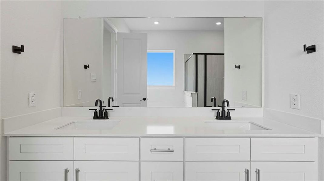 Bathroom with a shower stall, double vanity, and recessed lighting