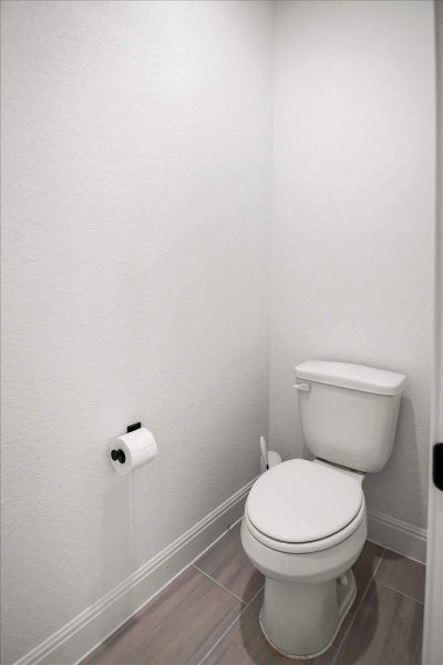 A compact and private powder room features durable tile flooring, perfect for daily use.