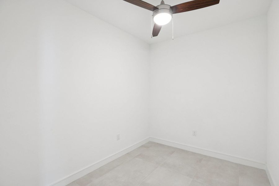 Unfurnished room with baseboards and ceiling fan