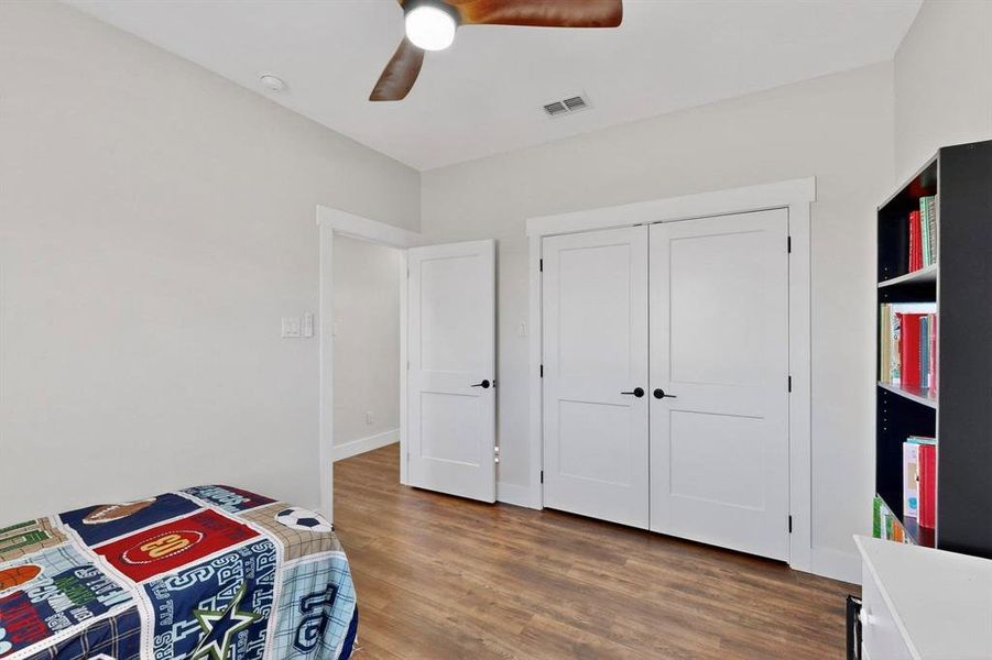 Unfurnished bedroom featuring dark wood-style flooring, a ceiling fan, and a closet