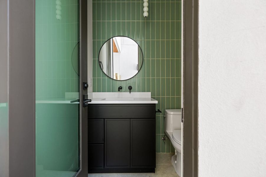 A stylish modern vanity and vertical tiling define this compact washroom space.