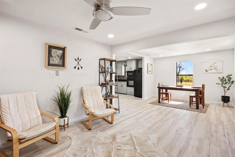 Living area with light hardwood / wood-style flooring and ceiling fan