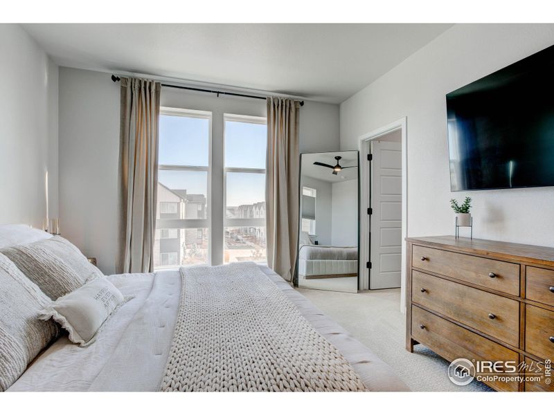 Primary Bedroom with tall ceilings and ceiling fan. Access to walk-in closet
