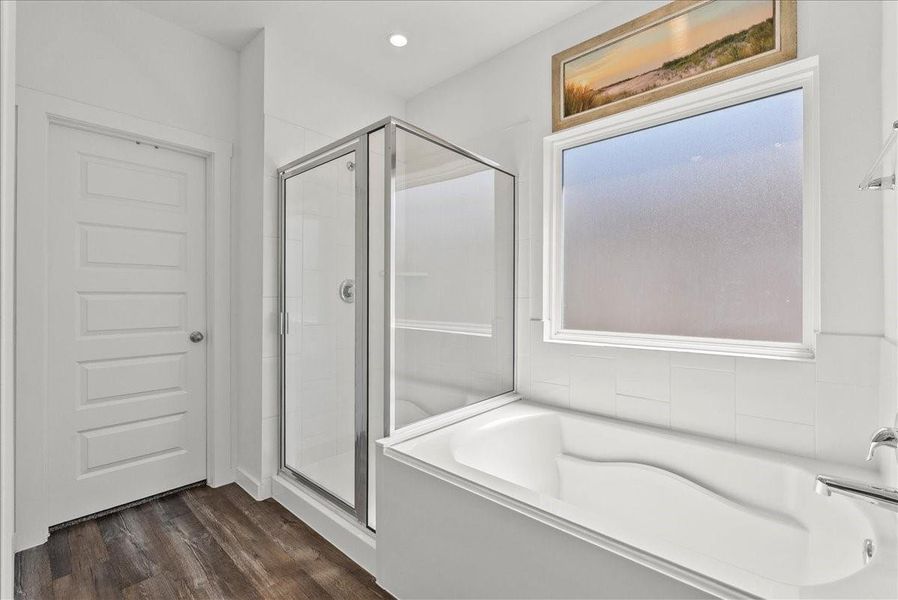 The private primary en-suite bath offers dual vanities, walk-in closet, soaking tub, double sinks, and a walk-in shower.