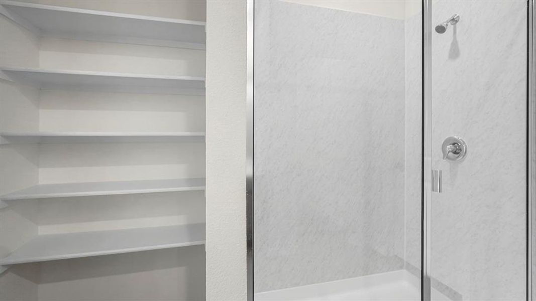 Walk-in shower with clear glass enclosure and chrome fixtures