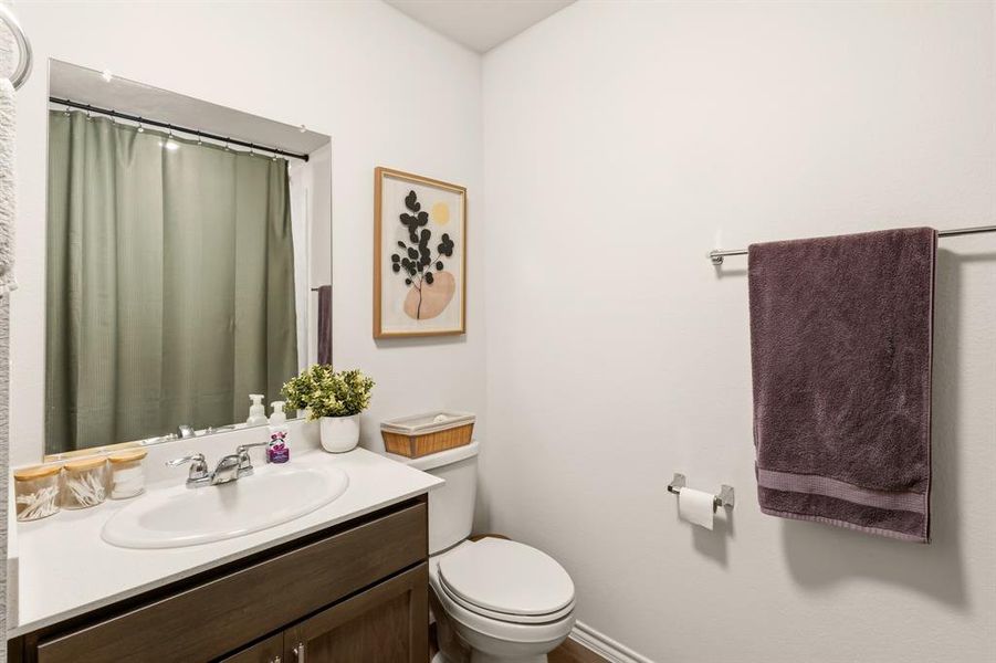 Bathroom featuring a vanity with a white countertop and a mirror, a toilet, and a towel bar Bathroom featuring a vanity with a white countertop and a mirror, a toilet, and a towel bar
