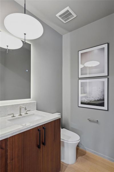 A refined bathroom featuring a contemporary vanity with a sleek faucet and light-toned flooring.