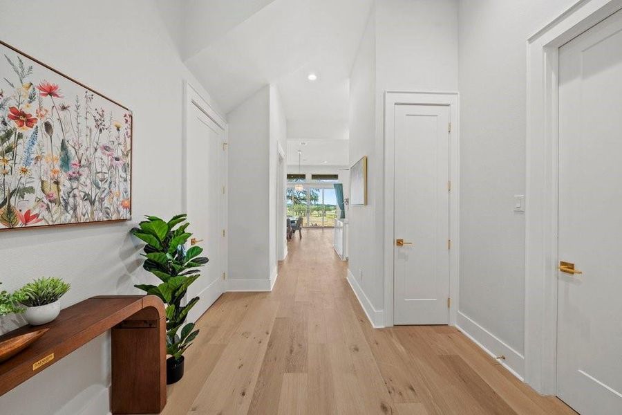 This airy hallway sets the tone with clean lines, tall ceilings, and warm flooring—leading you effortlessly into the heart of the home with a peek at the stunning Hill Country views beyond