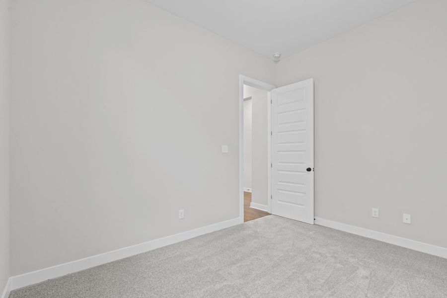 Empty room with baseboards and light carpet Empty room with baseboards and light carpet