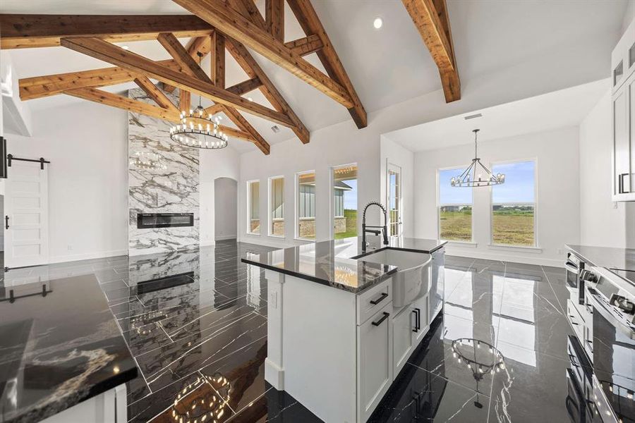 Kitchen featuring a chandelier, white cabinets, pendant lighting, dark marble finish floors, and high vaulted ceiling Kitchen featuring a chandelier, white cabinets, pendant lighting, dark marble finish floors, and high vaulted ceiling