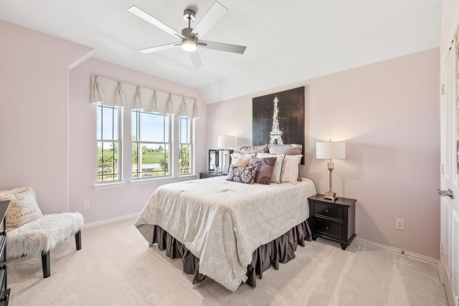 Bedroom with pink walls, vaulted ceiling, ceiling fan, and large windows with natural light Bedroom with pink walls, vaulted ceiling, ceiling fan, and large windows with natural light