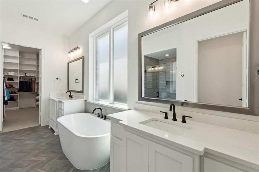 Bathroom featuring vanity, parquet flooring, and separate shower and tub